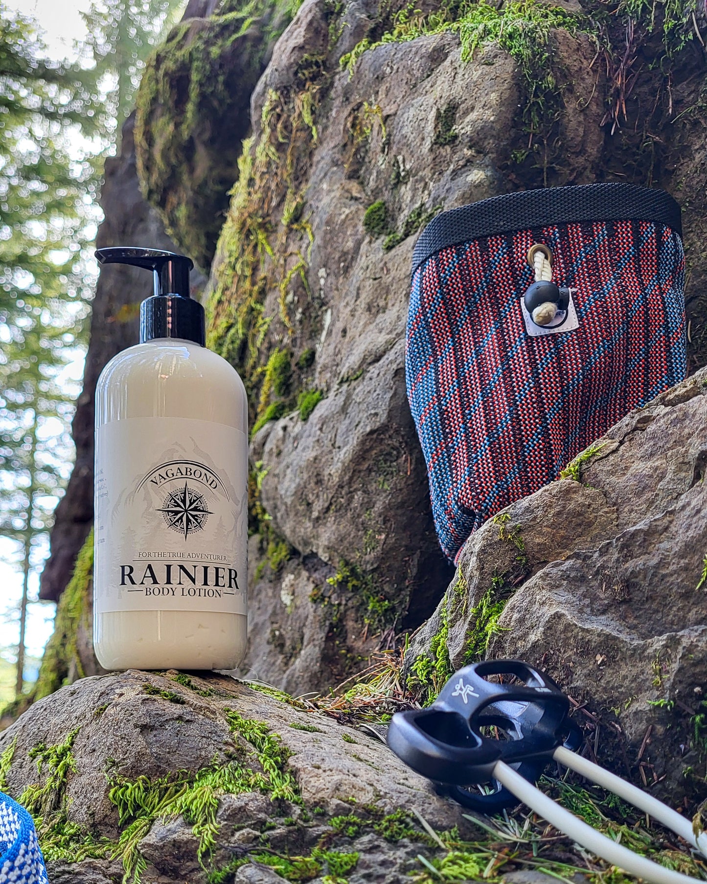 Rainier natural lotion warm cinnamon scent displayed with climbing gear against a mountainside backdrop.