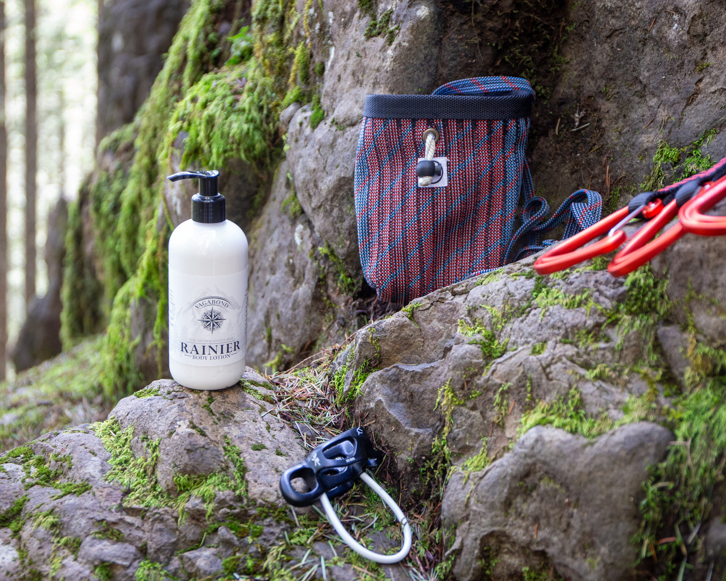 Rainier natural lotion warm cinnamon scent displayed with climbing gear against a mountainside backdrop.