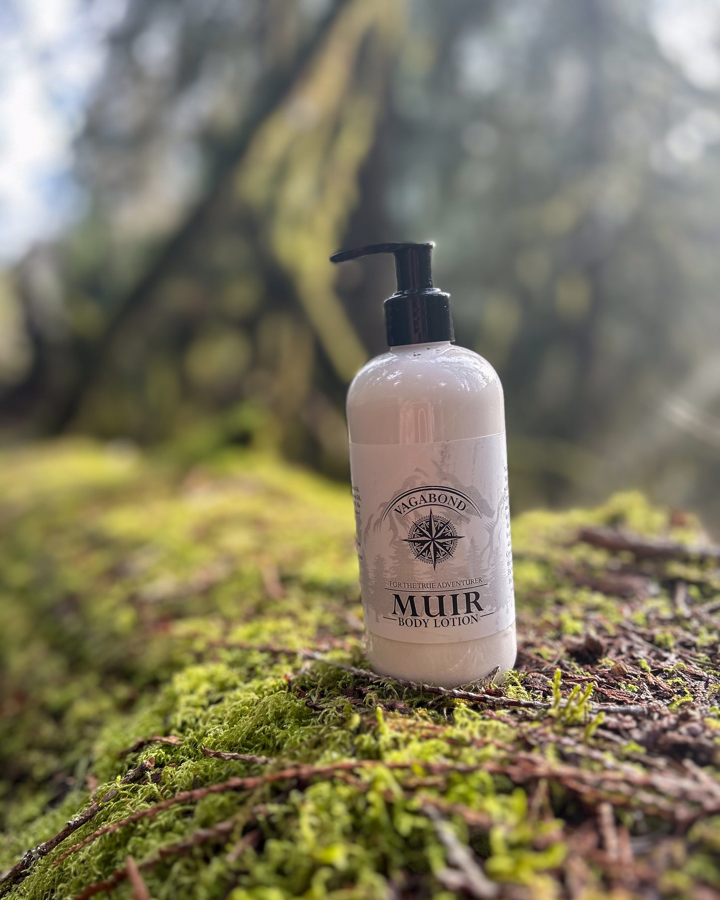 Muir natural lotion evergreen scent displayed on a mossy branch backdrop