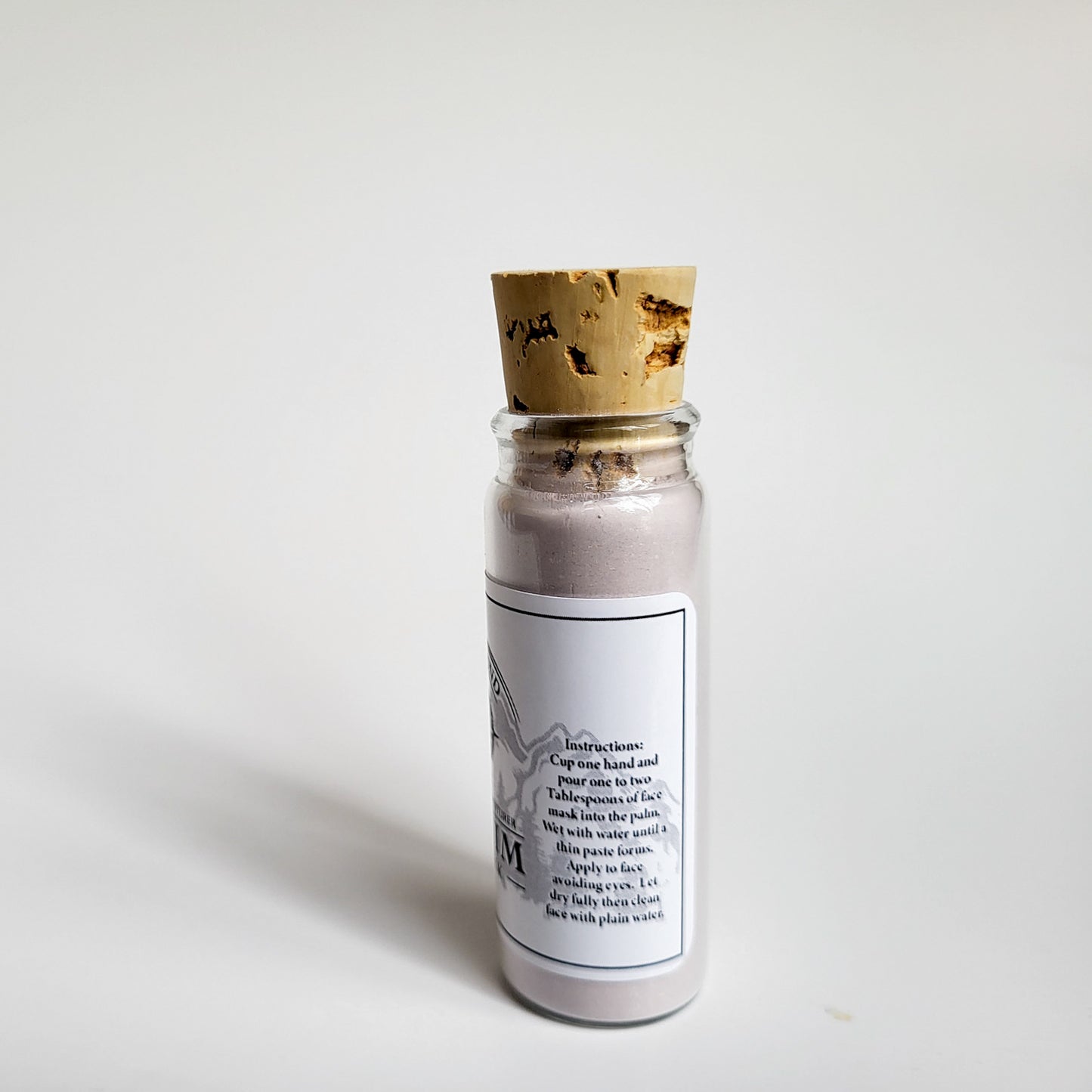 Sequim natural clay mask in corked glass bottle displayed against a plain white backdrop showing instructions on the label
