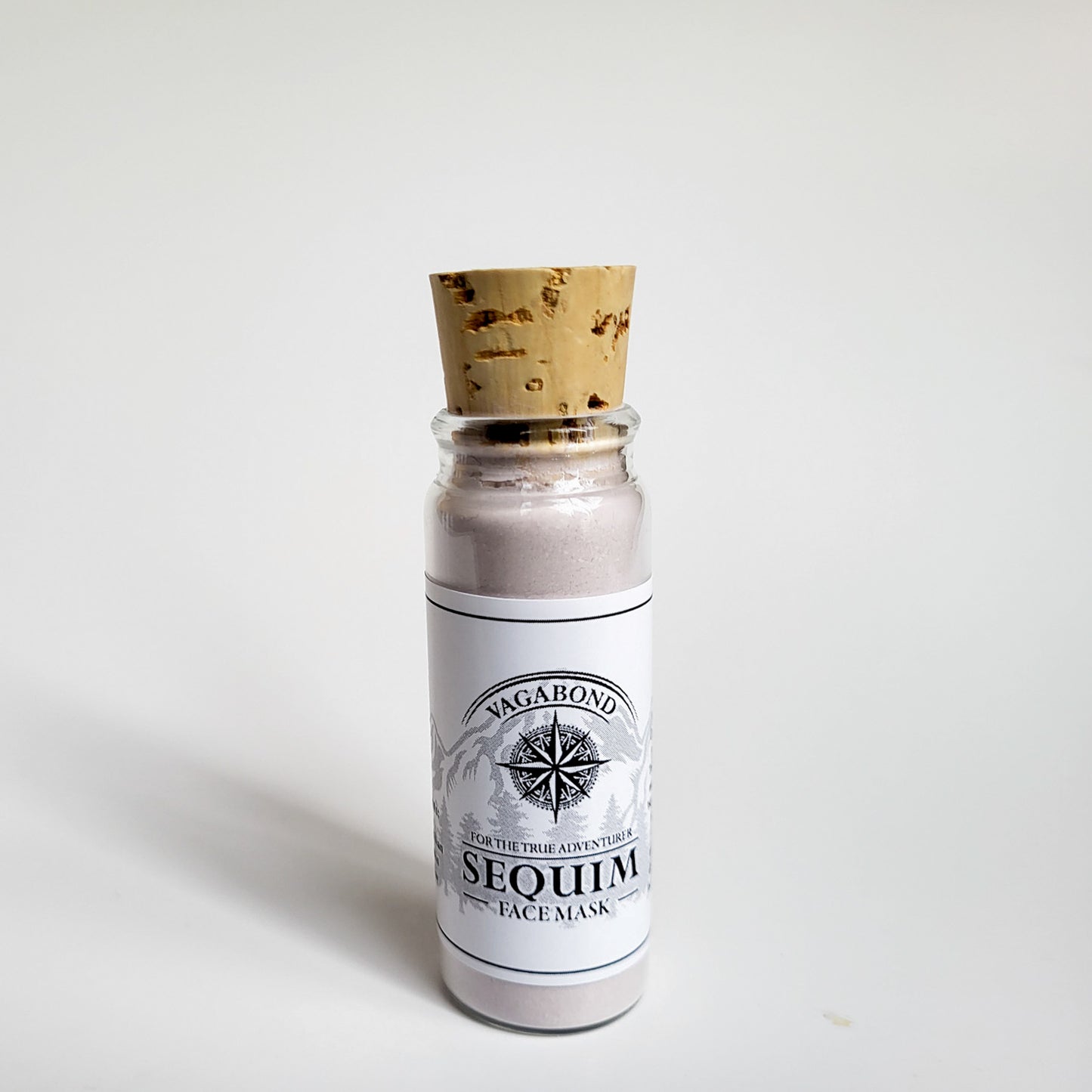 Sequim natural clay mask in corked glass bottle displayed against a plain white backdrop showing logo on the label