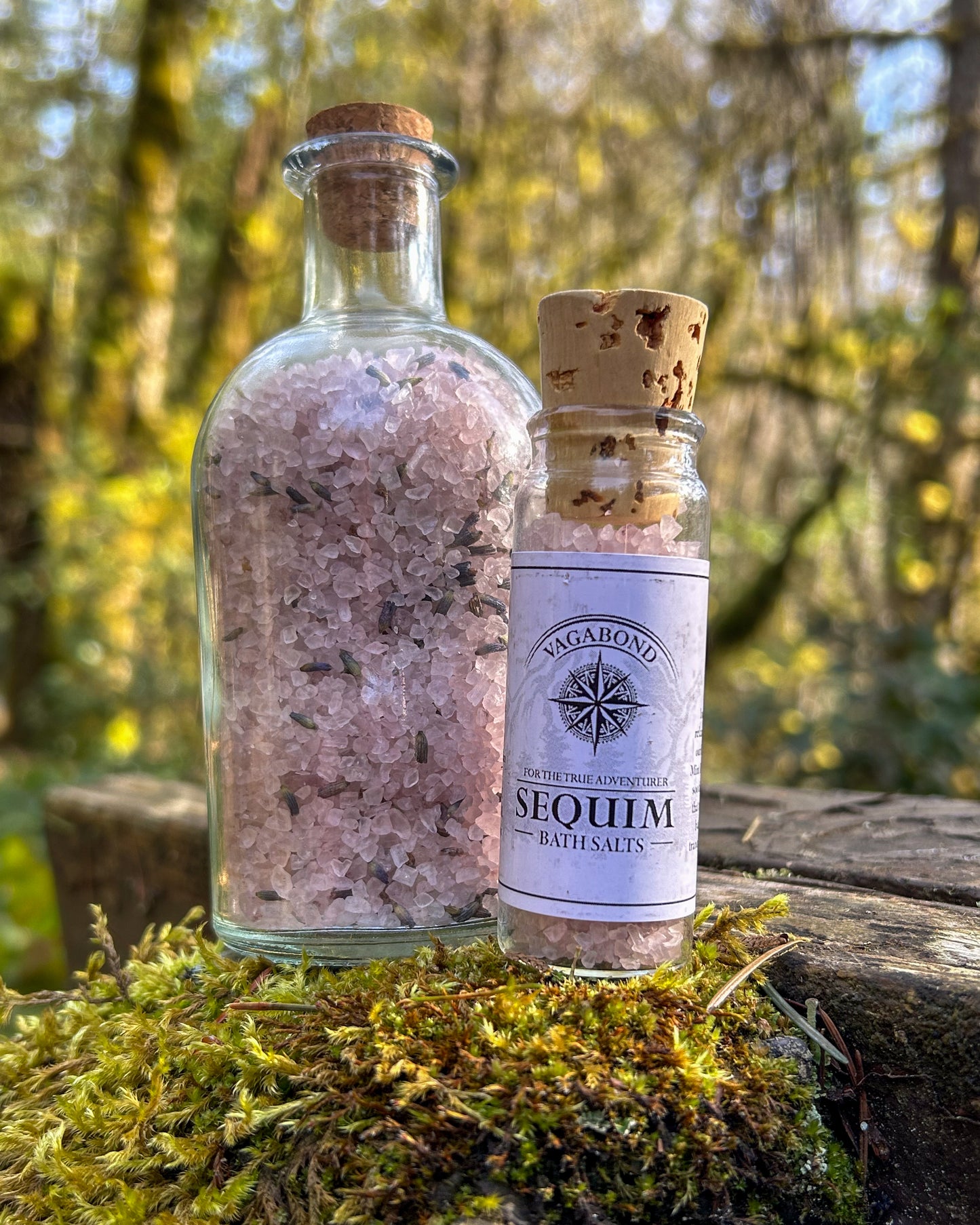 Sequim natural bath salts lavender mint scent in corked glass bottle displayed on a mossy stump backdrop