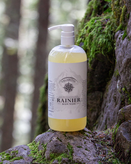 Rainier natural body wash warm cinnamon scent displayed against a mountainside backdrop