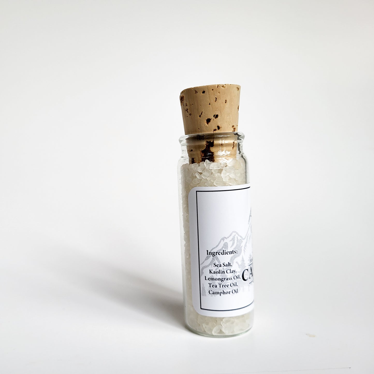 Cascadia natural bath salts lemon citrus scent in corked glass bottle displayed against a white backdrop showing ingredients on label