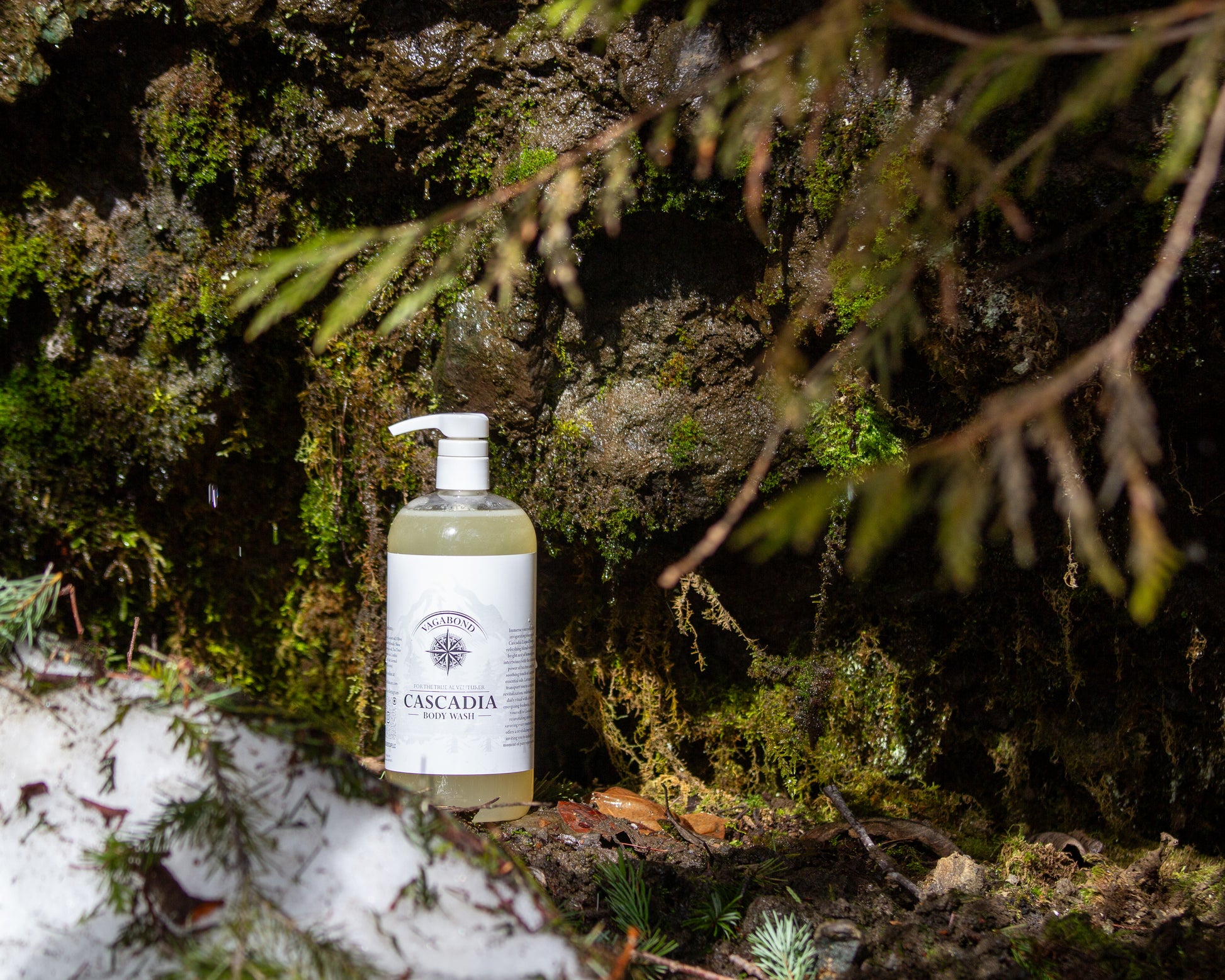 Cascadia natural body wash lemon citrus scent displayed against a dripping mountainside moss backdrop.