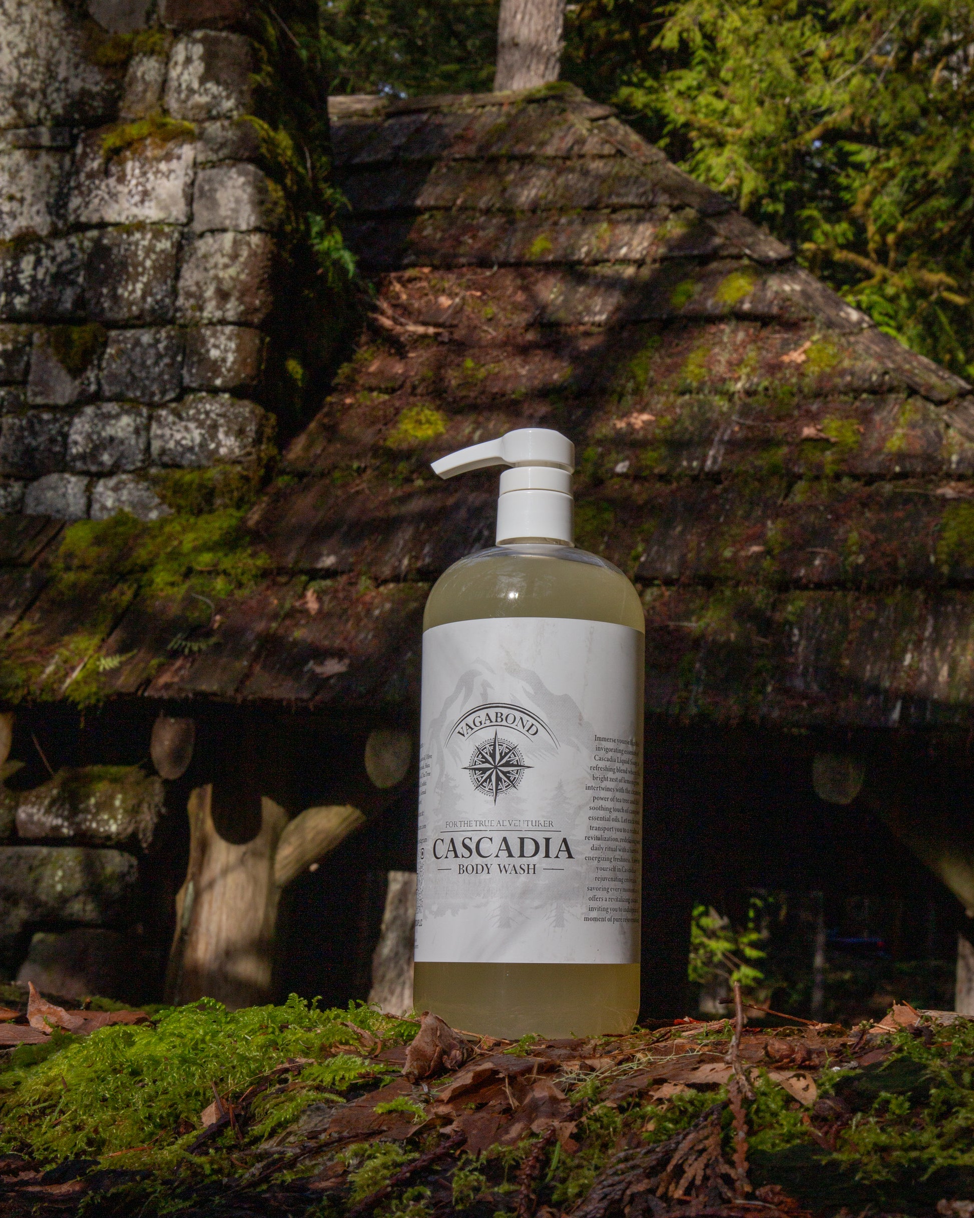 Cascadia natural body wash lemon citrus scent displayed against a mossy cabin backdrop.