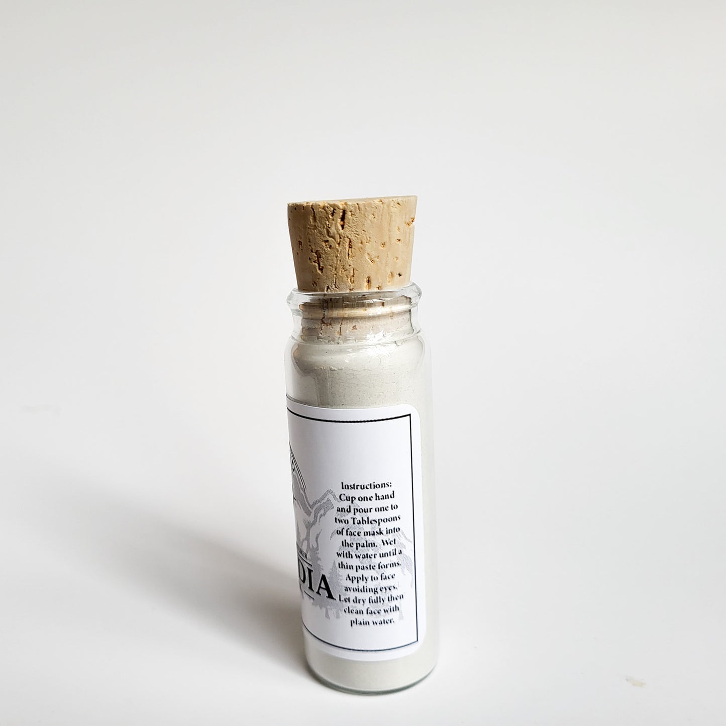 Cascadia natural clay mask in corked glass bottle displayed against a plain white backdrop showing instructions on the label