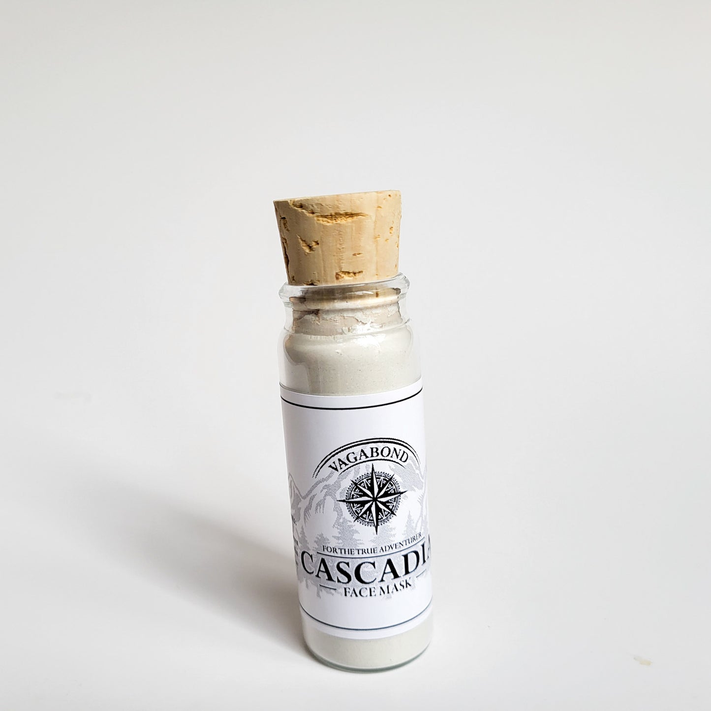 Cascadia natural clay mask in corked glass bottle displayed against a plain white backdrop showing logo on the label