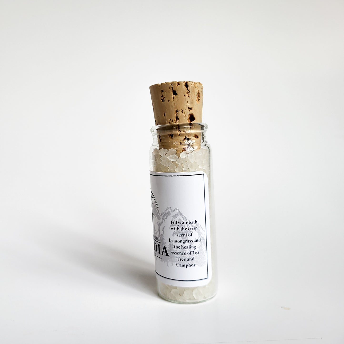 Cascadia natural bath salts lemon citrus scent in corked glass bottle displayed against a white backdrop showing description on label