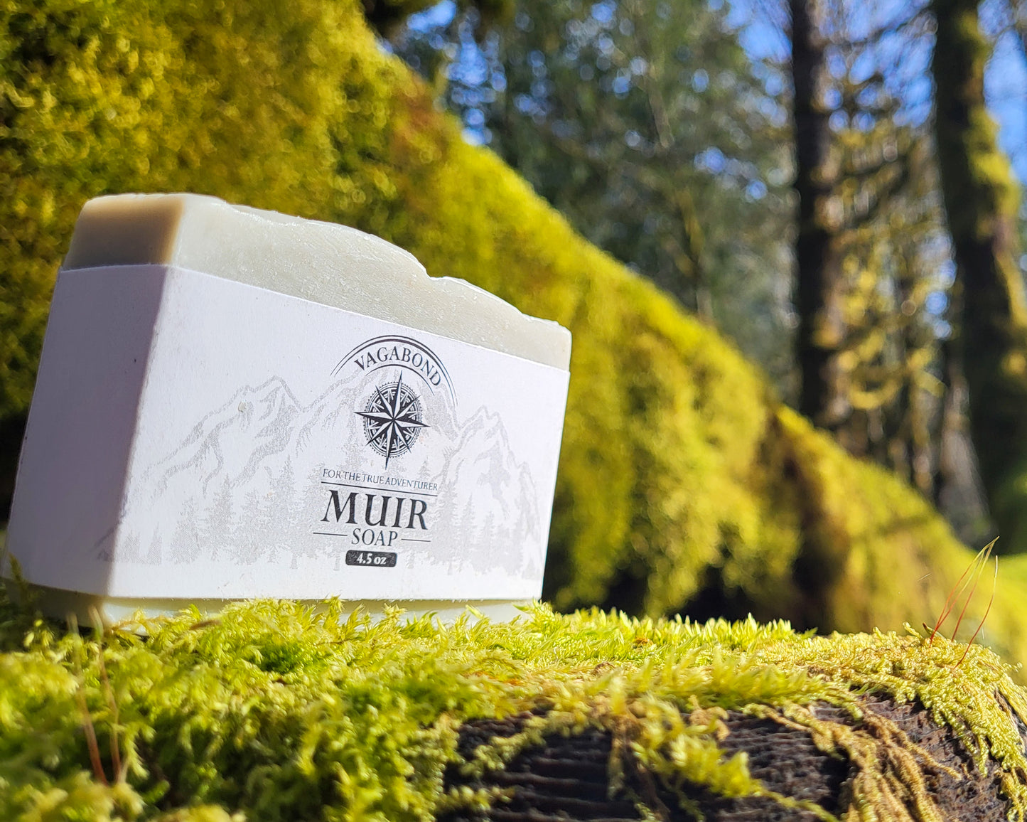 Muir natural bar soap evergreen scent displayed on a mossy branch backdrop