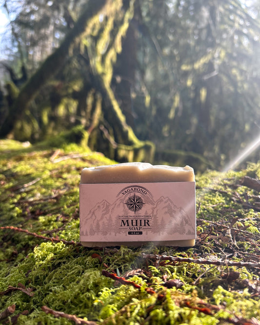 Muir natural bar soap evergreen scent displayed on a mossy log backdrop