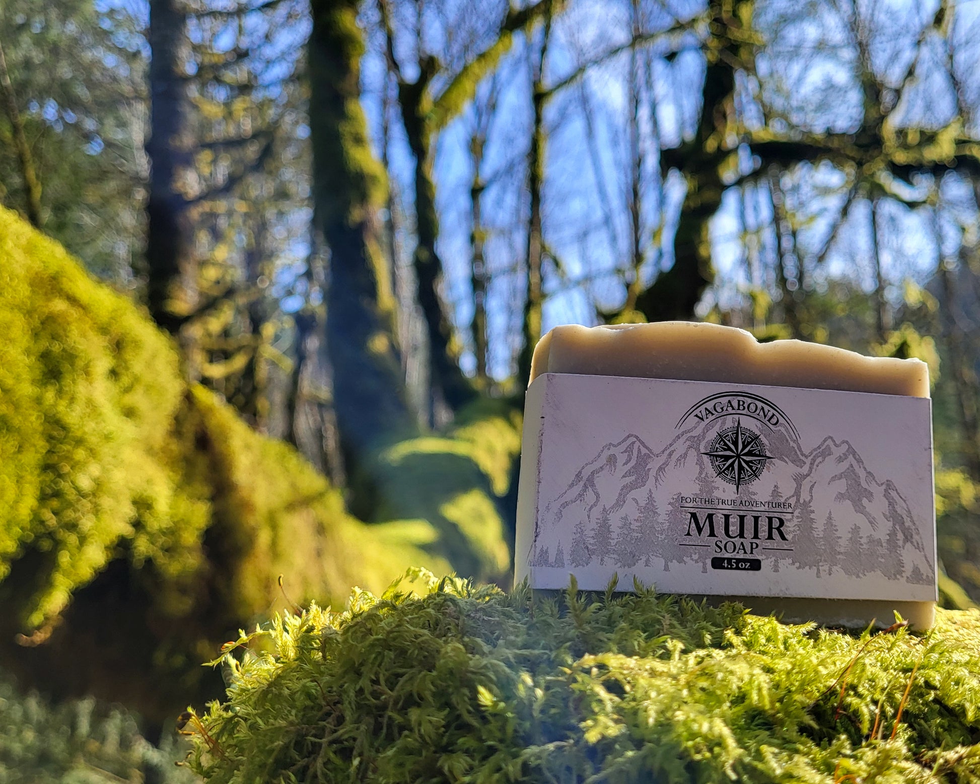 Muir natural bar soap evergreen scent displayed on a mossy branch backdrop