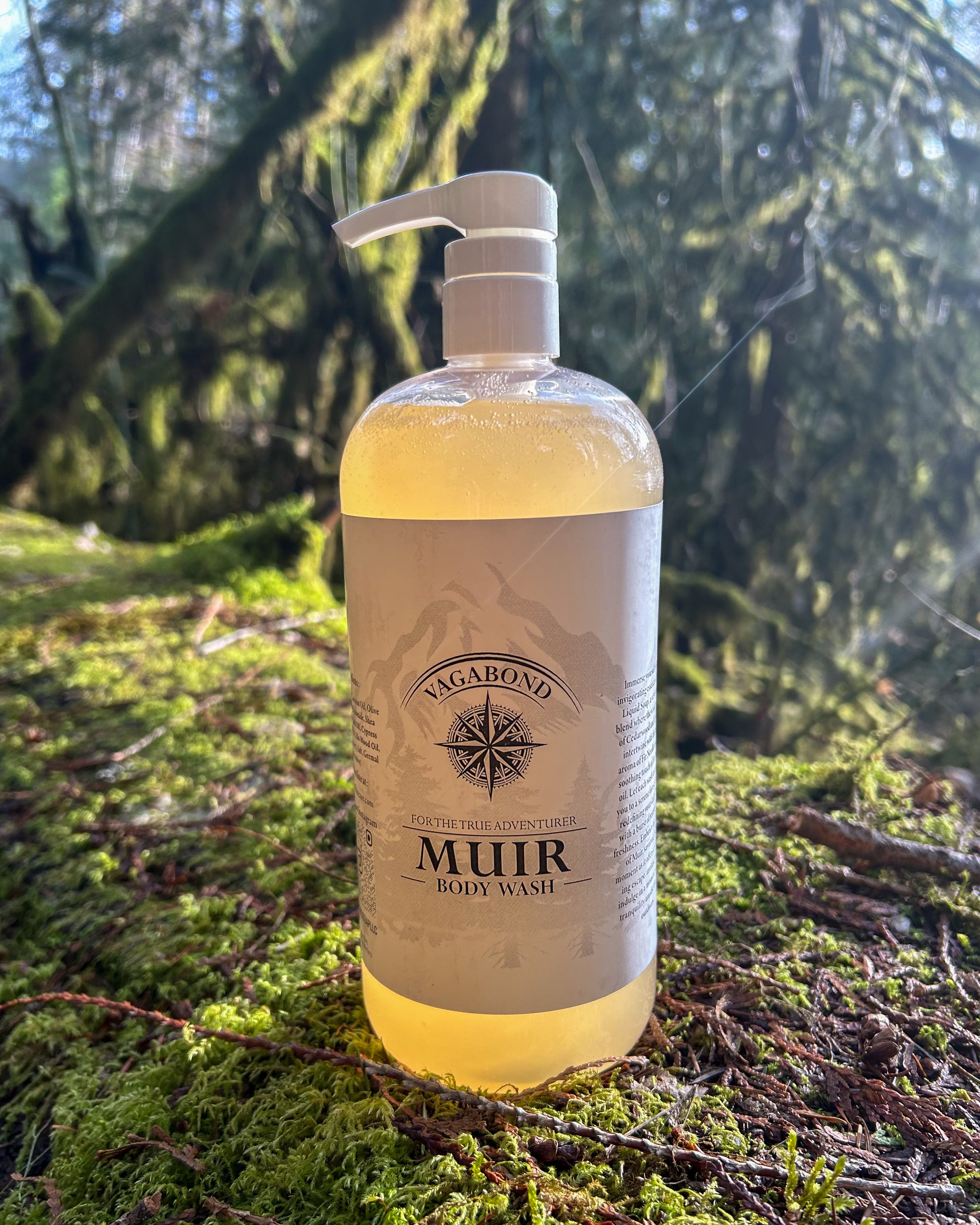 Muir natural body wash evergreen scent in corked glass bottles displayed on a mossy log backdrop