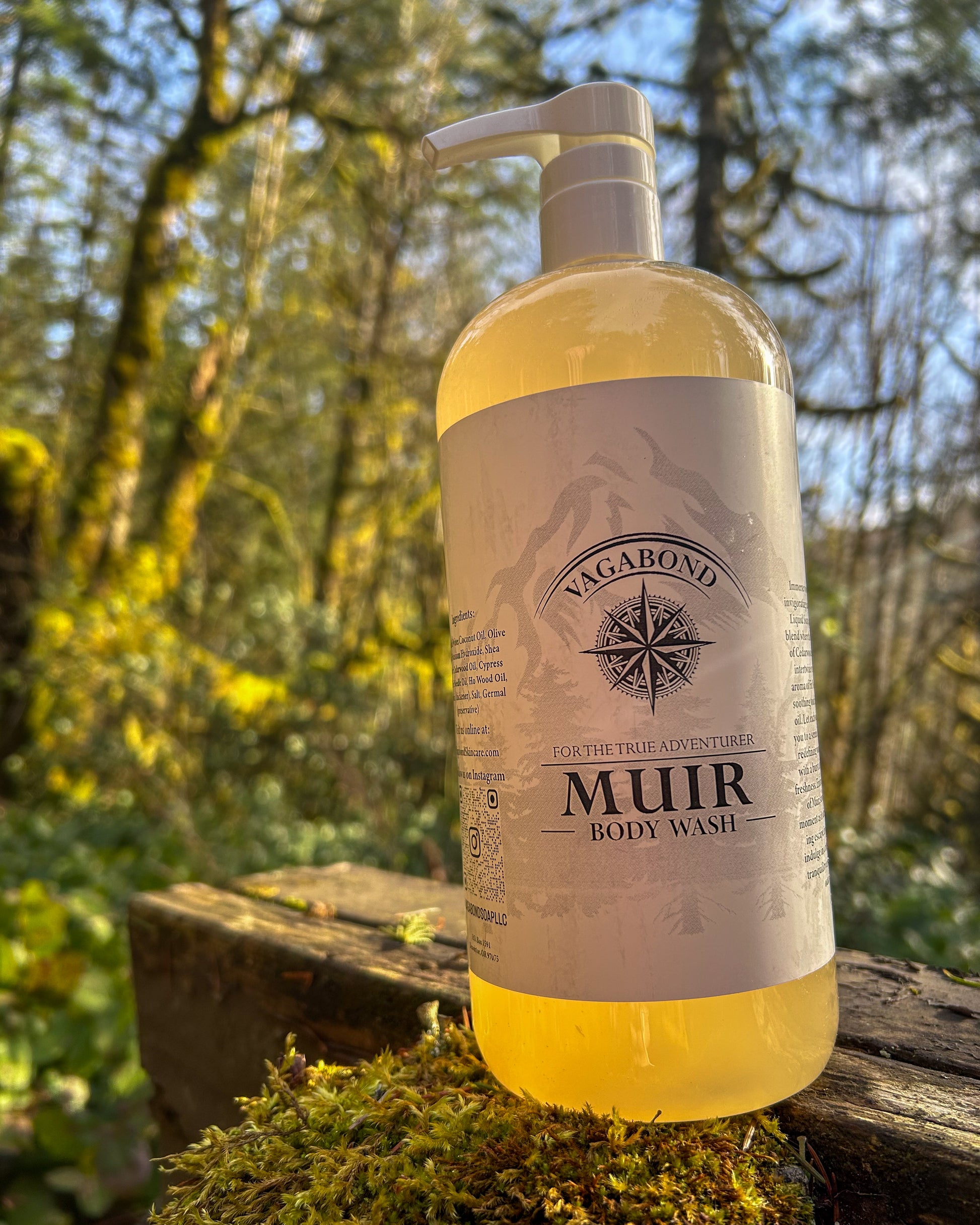 Muir natural body wash evergreen scent in corked glass bottles displayed on a mossy post with forest backdrop