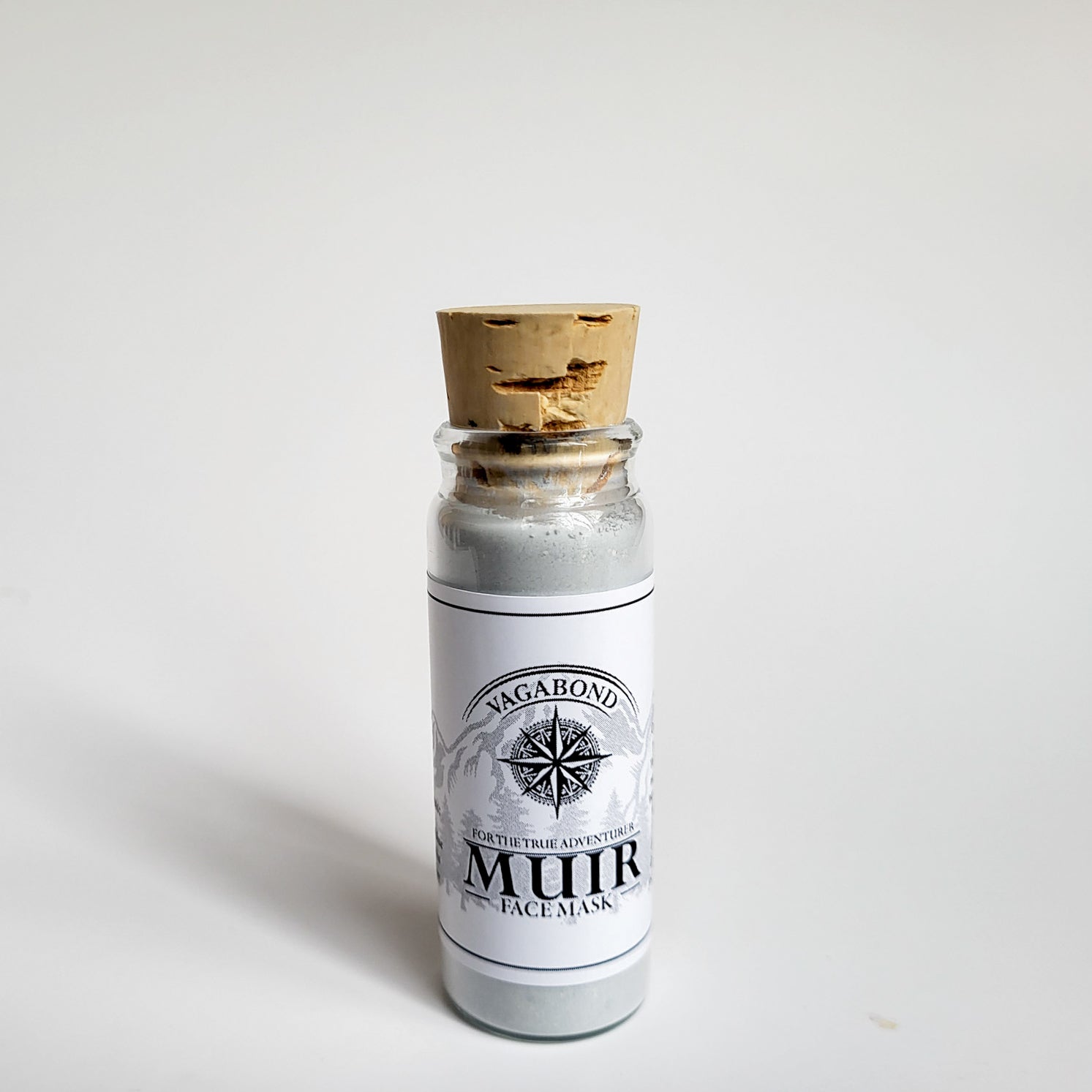 Muir natural clay mask in corked glass bottle displayed against a plain white backdrop showing logo on the label