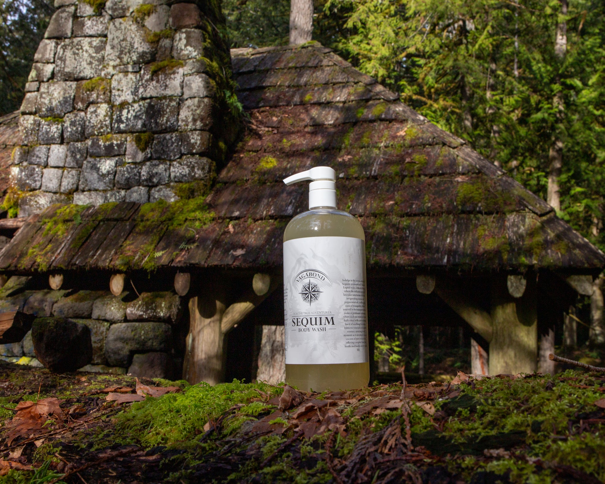 Sequim natural body wash lavender mint scent in corked glass bottle displayed on a mossy cabin backdrop