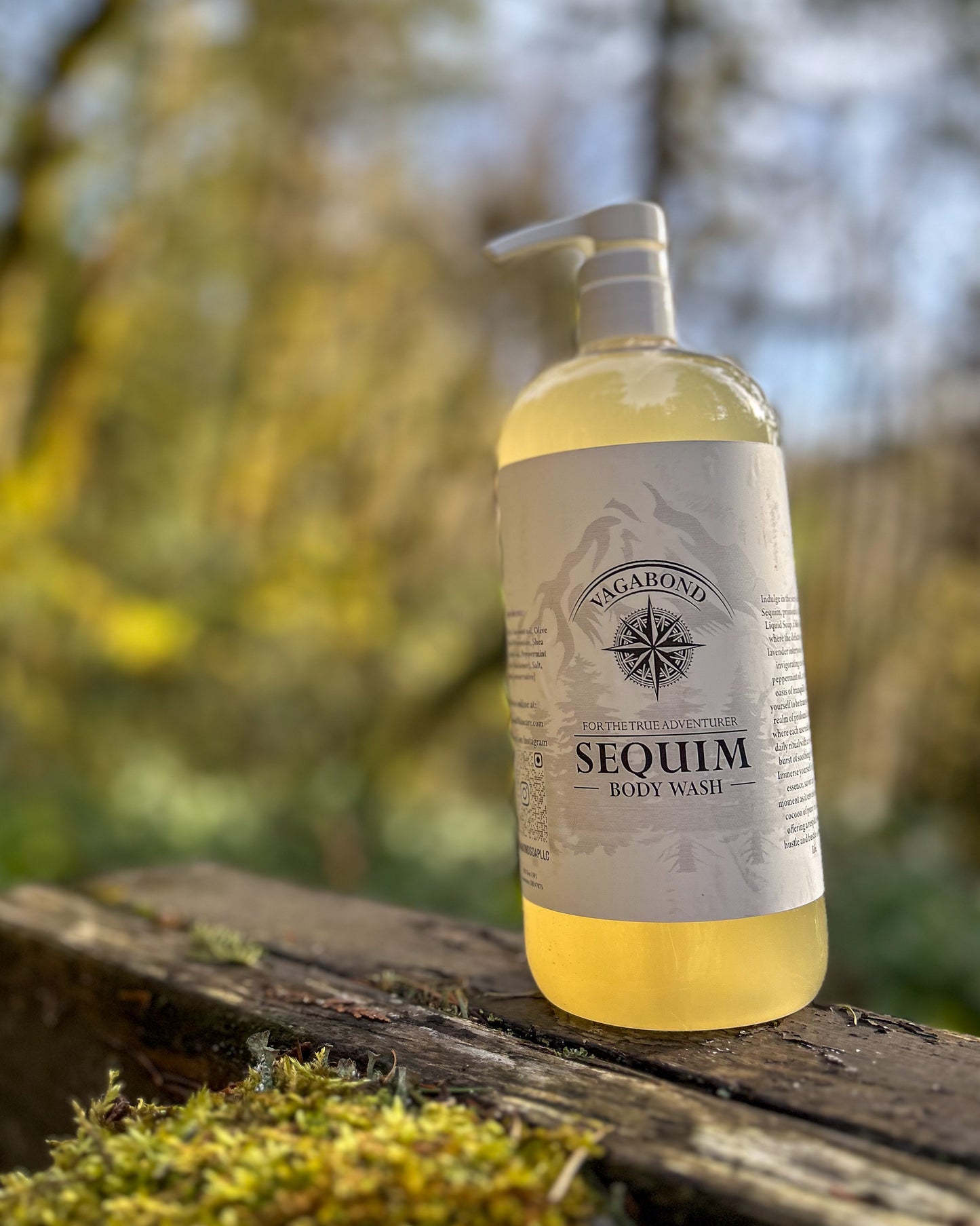 Sequim natural body wash lavender mint scent in corked glass bottle displayed on a mossy stump backdrop